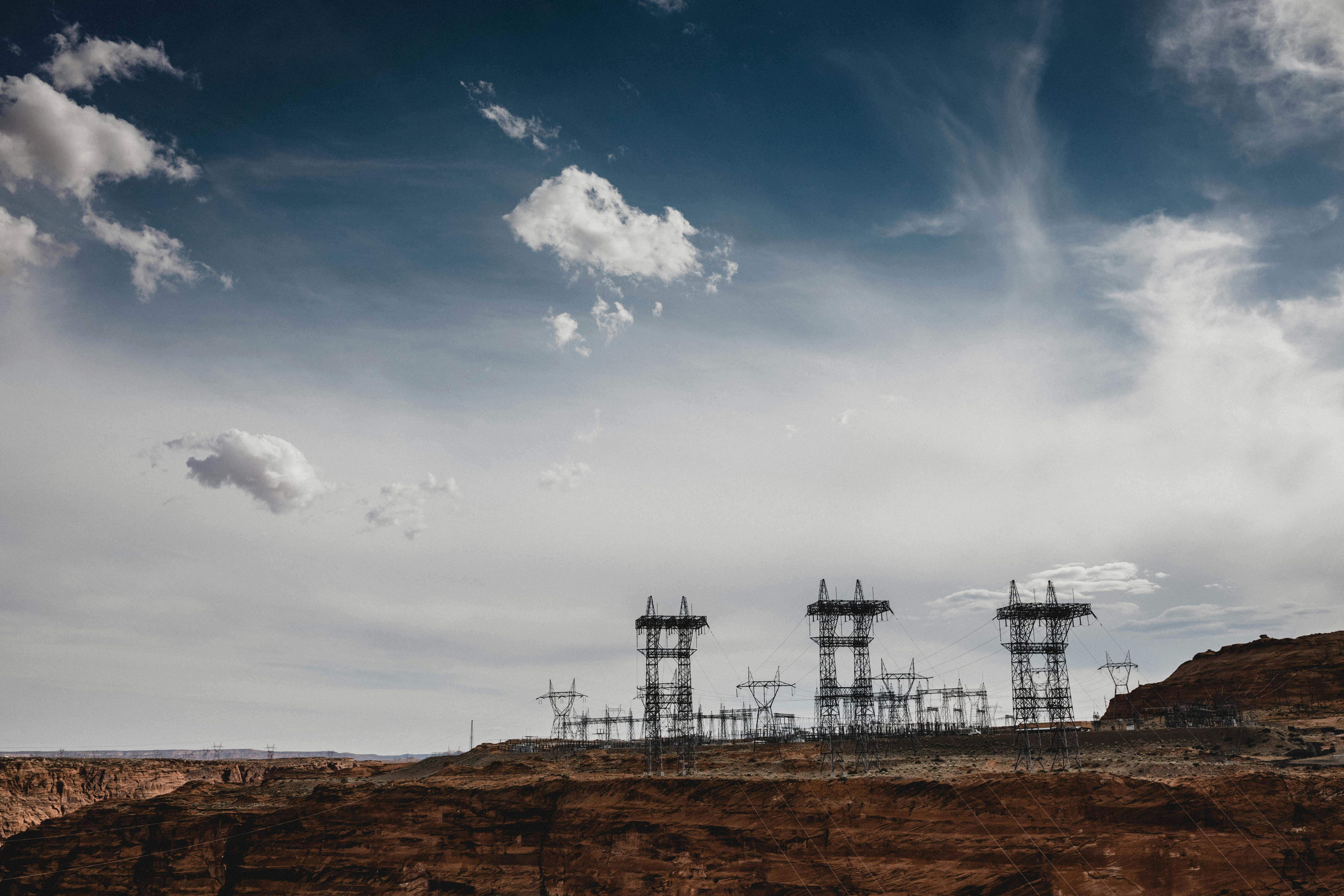High-voltage power grid infrastructure stretching across an energy landscape.